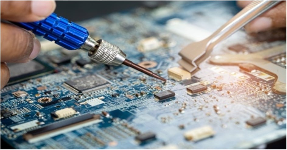 Hands working on an electronic circuit board
